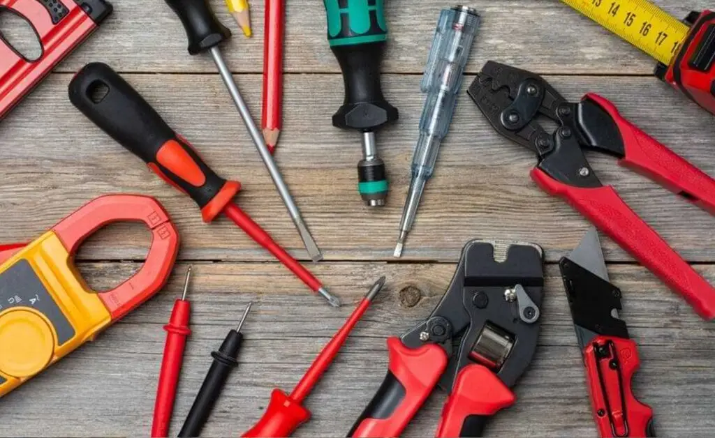 Professional electrical hand tools including screwdrivers, crimpers, multimeter, utility knife, and test leads